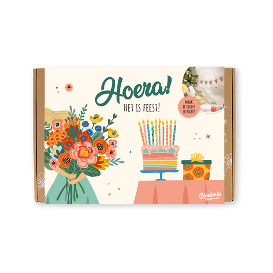 Feestelijke giftbox met Blossombs zaadbommetjes en een vrolijke, gekleurde banderol. Met daarop de tekst: Hoera, het is feest!