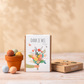Geschenkdoosje met tekst 'dank je wel'  en potje met zaadbommetjes op tafel