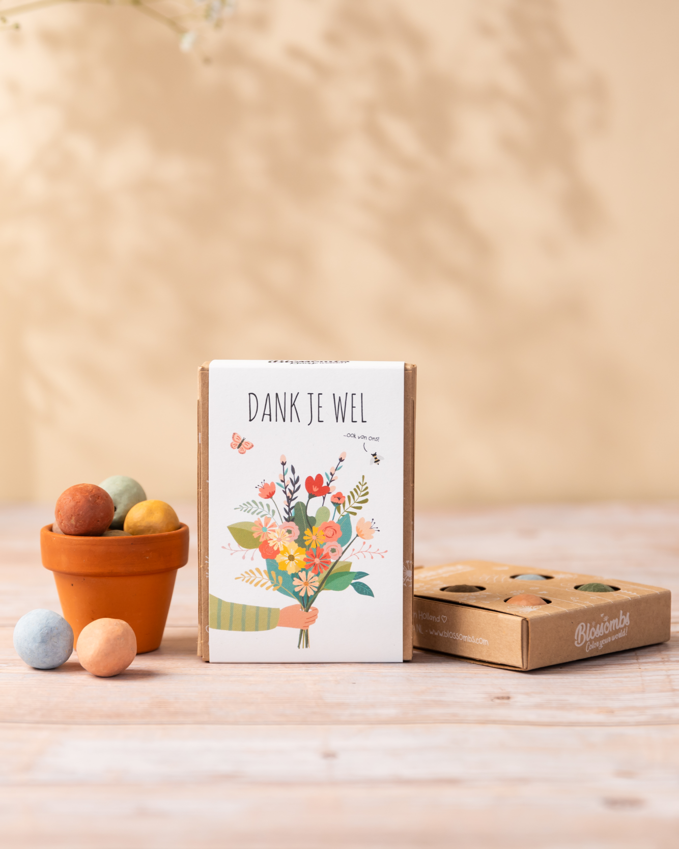 Geschenkdoosje met tekst 'dank je wel'  en potje met zaadbommetjes op tafel